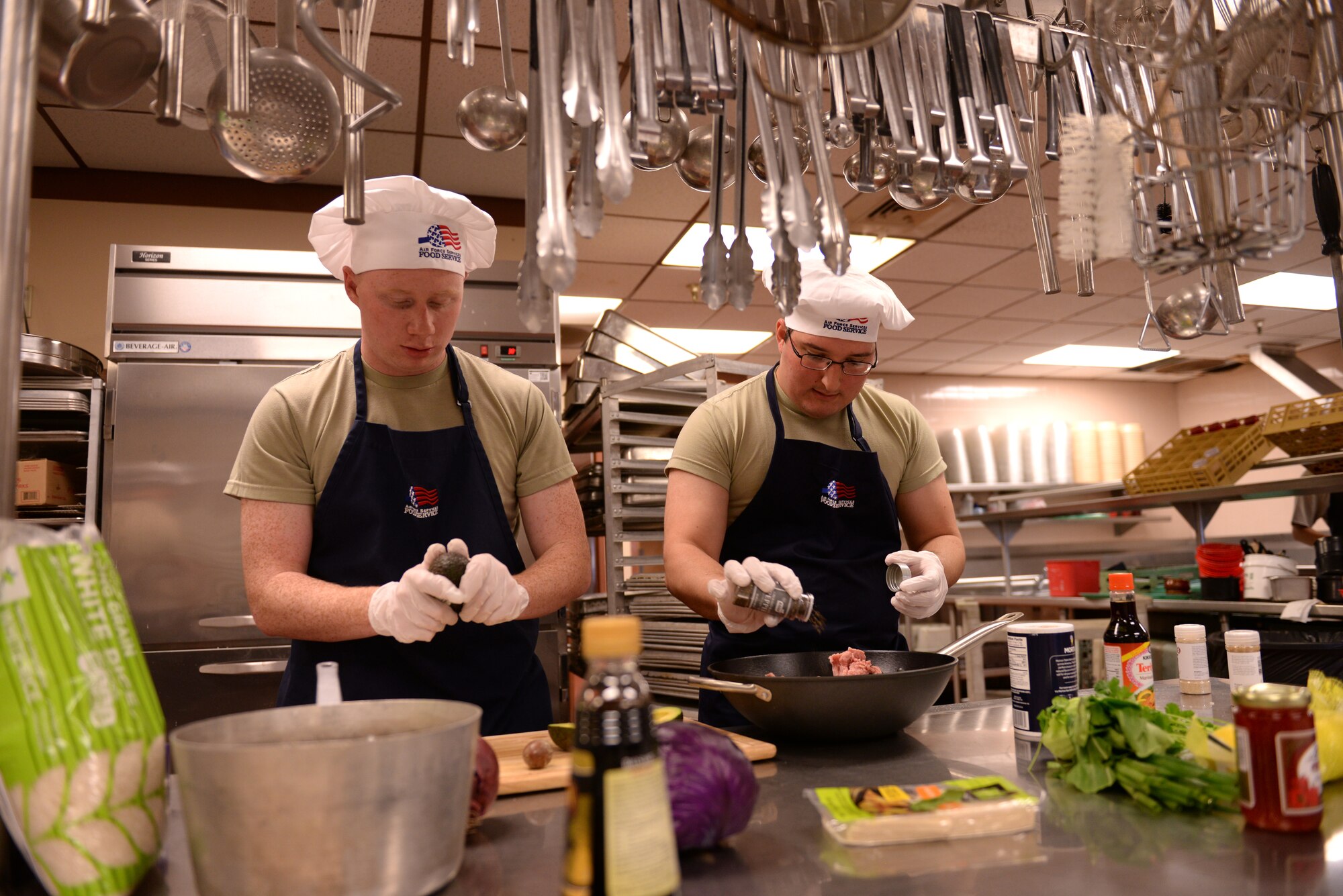 Airman 1st Class Joel Hendrickson, 56th Logistics Readiness Squadron vehicle operator, and Senior Airman David Escobar, 56th Force Support Squadron food service apprentice, prepare Asian-style food for judging during the Taste of Luke cooking competition at Luke Air Force Base, Ariz., May 9, 2018. Three teams of Luke Airmen competed against each other in a competition to cook Asian-inspired food in honor of Asian-Pacific Islander Heritage Month, which takes place throughout May. (U.S. Air Force photo by Senior Airman Ridge Shan)