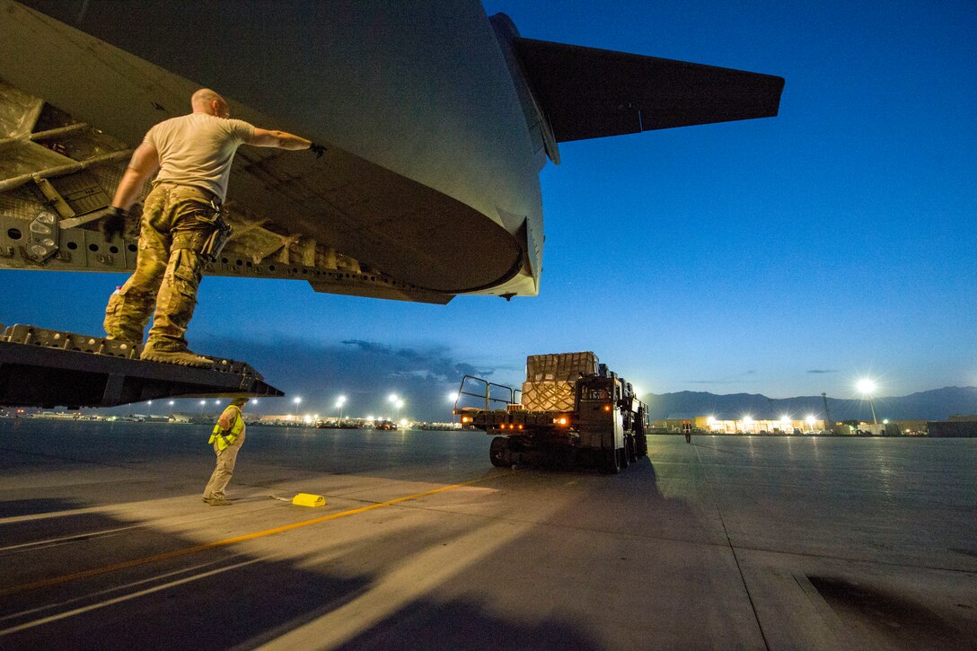 Heavy machine moves near an aircraft.