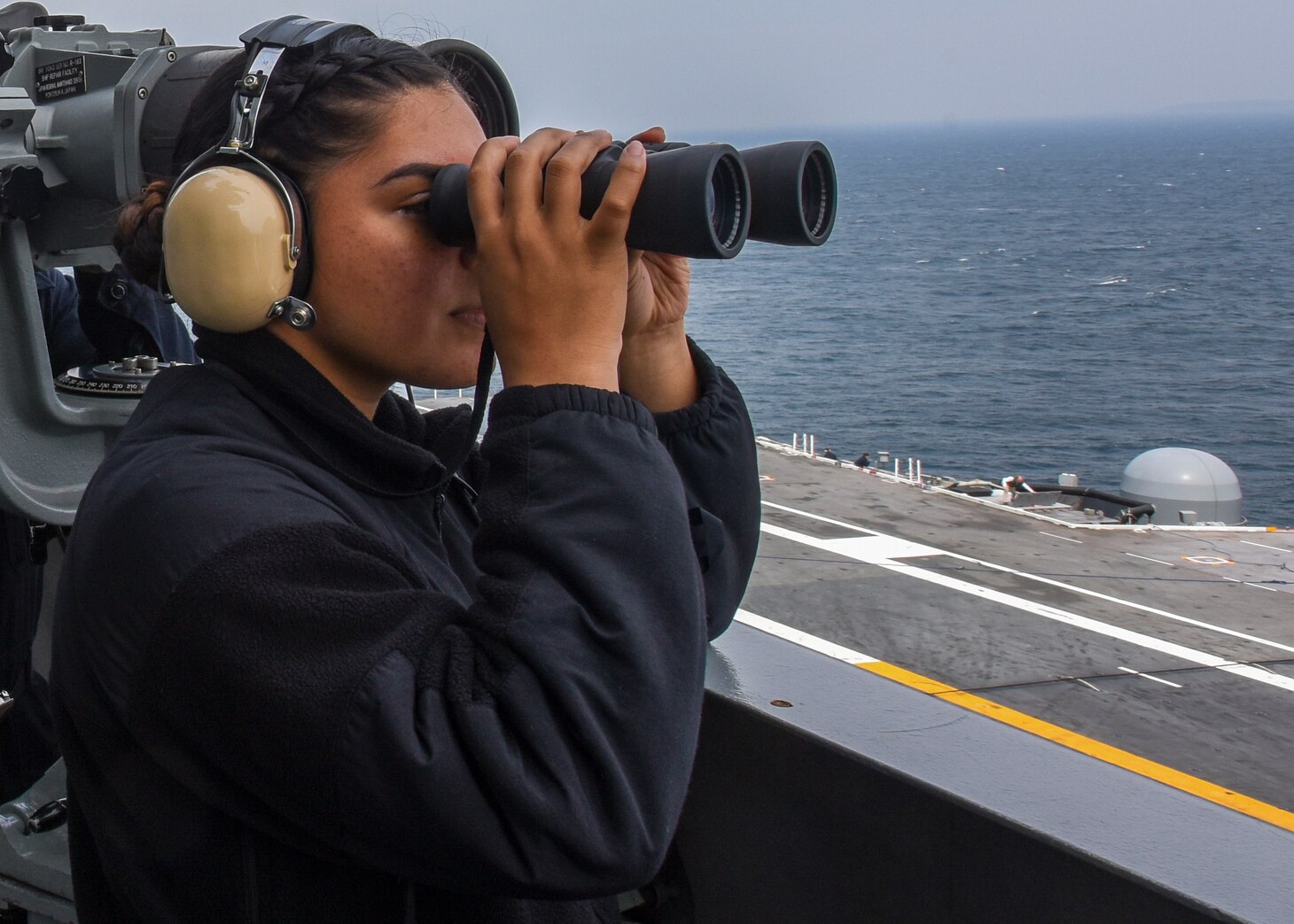 Operations Specialist Seaman Apprentice Stephanie Cruz, from San Diego, California, and Operations Specialist 3rd Class James Harrell, from St. Louis, Illinois, stand port-side lookout on vultures' row of the Navy's forward-deployed aircraft carrier, USS Ronald Reagan (CVN 76), as the ship returns to Commander, Fleet Activities Yokosuka following sea trials. Ronald Reagan, the flagship of Carrier Strike Group 5, provides a combat-ready force that protects and defends the collective maritime interests of its allies and partners in the Indo-Asia-Pacific region.