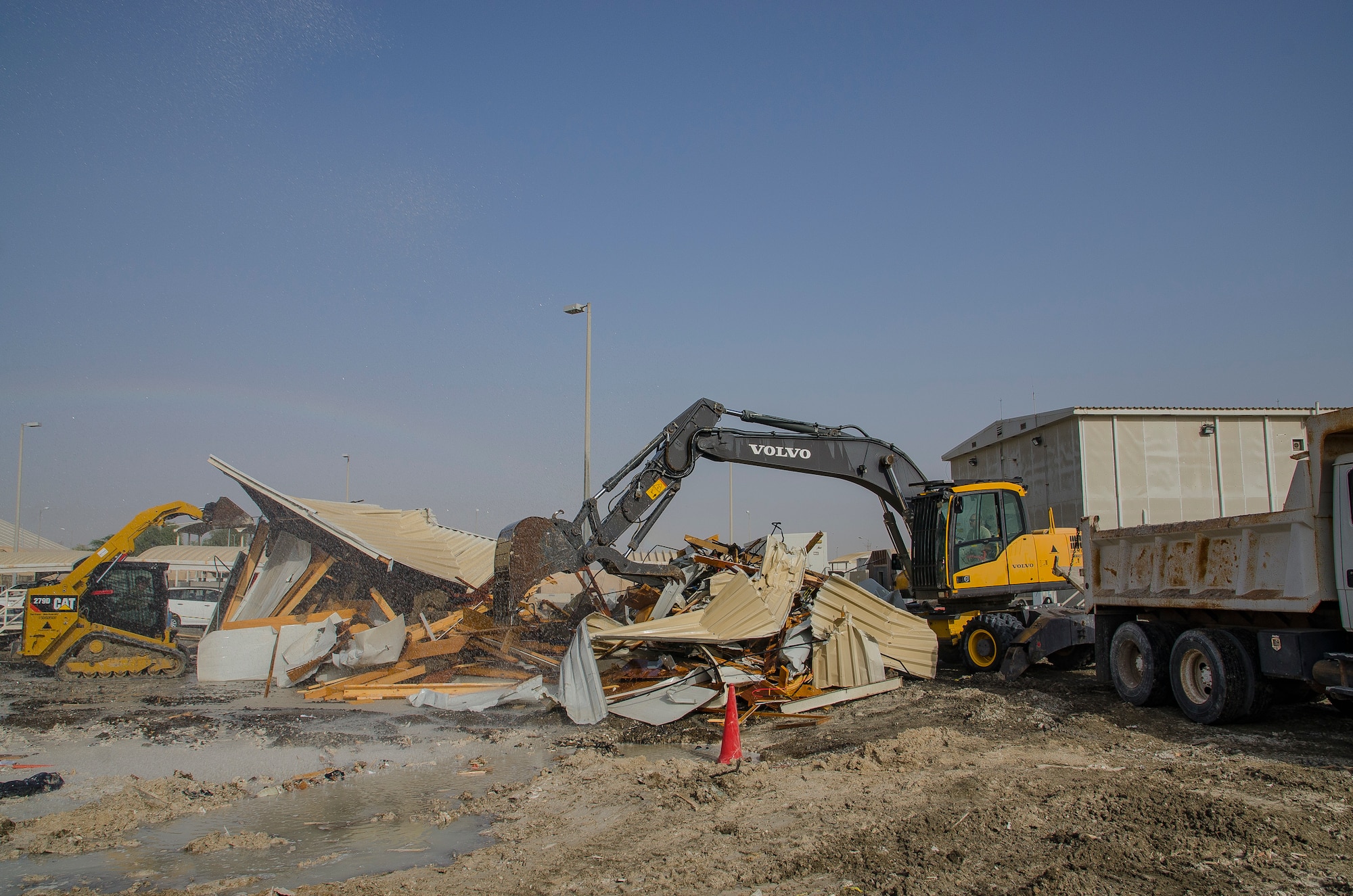 Staff Sgt. Nicholas Warkocz, pavements and heavy equipment operator, uses an excavator to remove debris from a demolished building May 9, 2018, at Al Dhafra Air Base, United Arab Emirates. Pavement and construction equipment airmen operate and maintain heavy construction equipment, and can also detonate explosives in order to care for and create the facilities we need most. (U.S. Air National Guard photo by Staff Sgt. Ross A. Whitley)