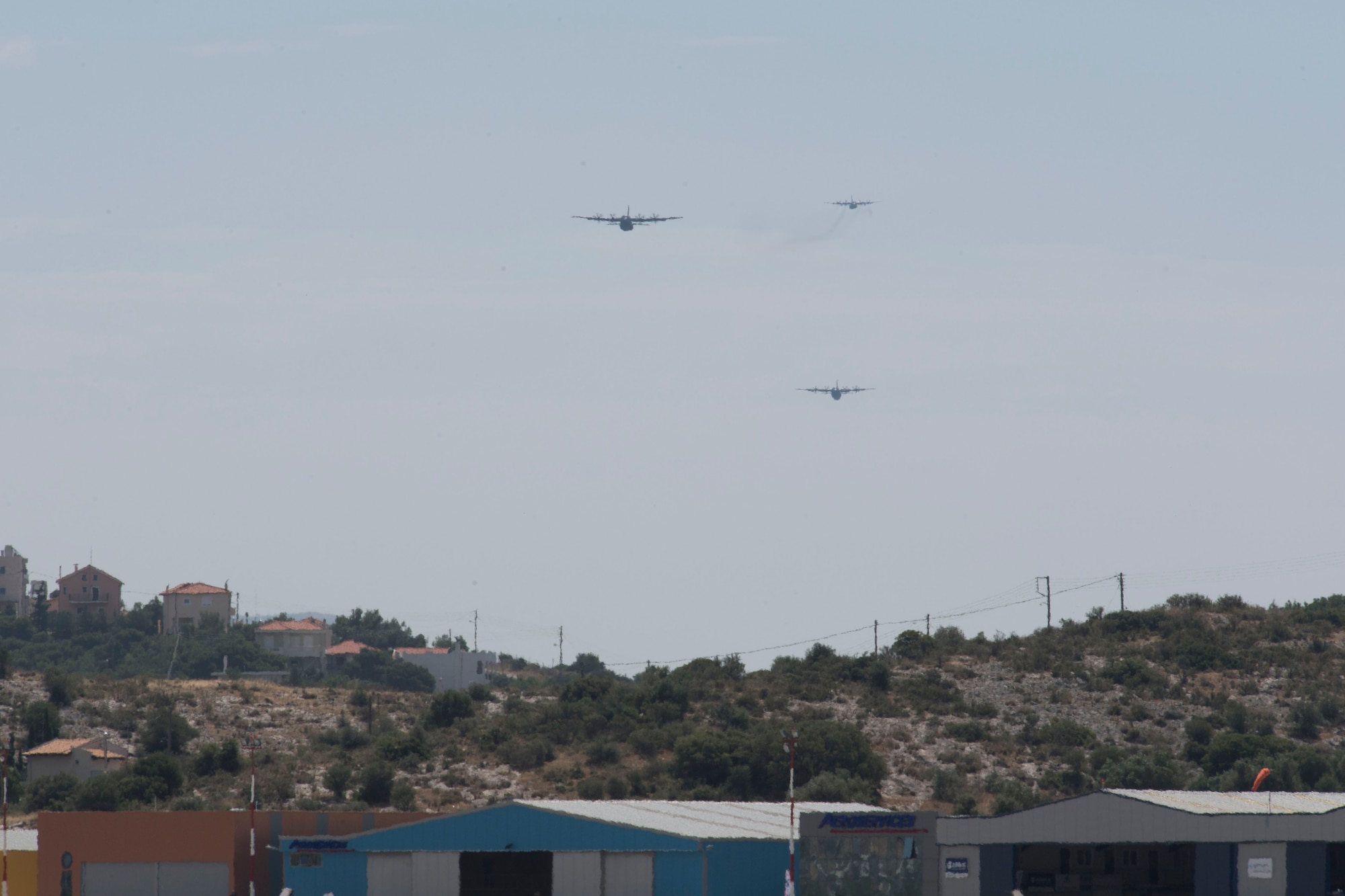 Two U.S. Air Force C-130J Super Hercules fly in formation in front of a Hellenic Air Force C-130H Hercules during the final training flight for Stolen Cerberus V, over Megara Drop Zone, Greece, May 15, 2018. Combined interfly missions such as these, enhance the interoperability capabilities and kills among allied and partner armed forces. (U.S. Air Force photo by Senior Airman Devin M. Rumbaugh)