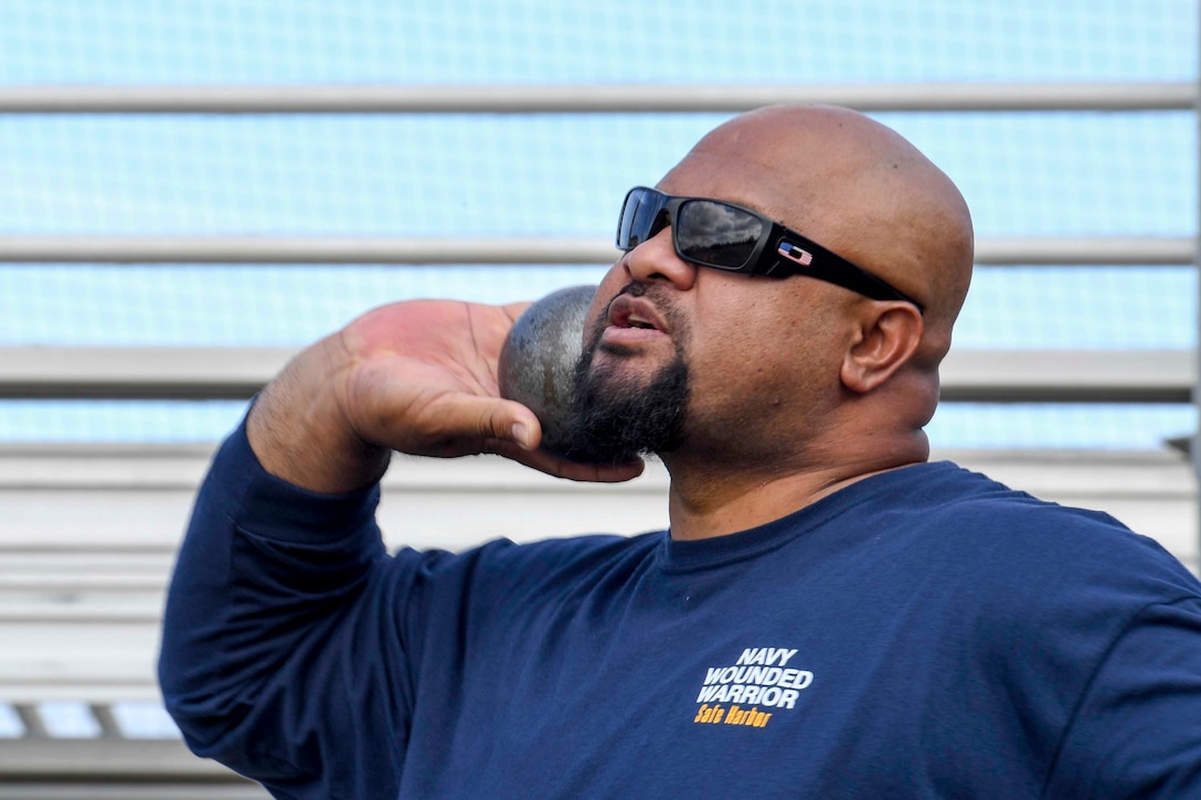 A sailor throws a shot put.