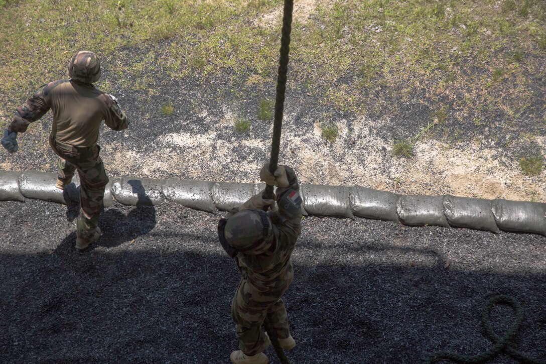 Members of the French Marines fast rope from a rappel tower during exercise Burmese Chase at Camp Lejeune, N.C., May 10, 2018. Burmese Chase is an annual U.S. led multi-lateral exercise that enables U.S. Marines to train with NATO allies and partner nations. This exercise strengthens partner nation security as well as enhances force readiness. (U.S. Marine Corps photo by Lance Cpl. Caleb Maher)