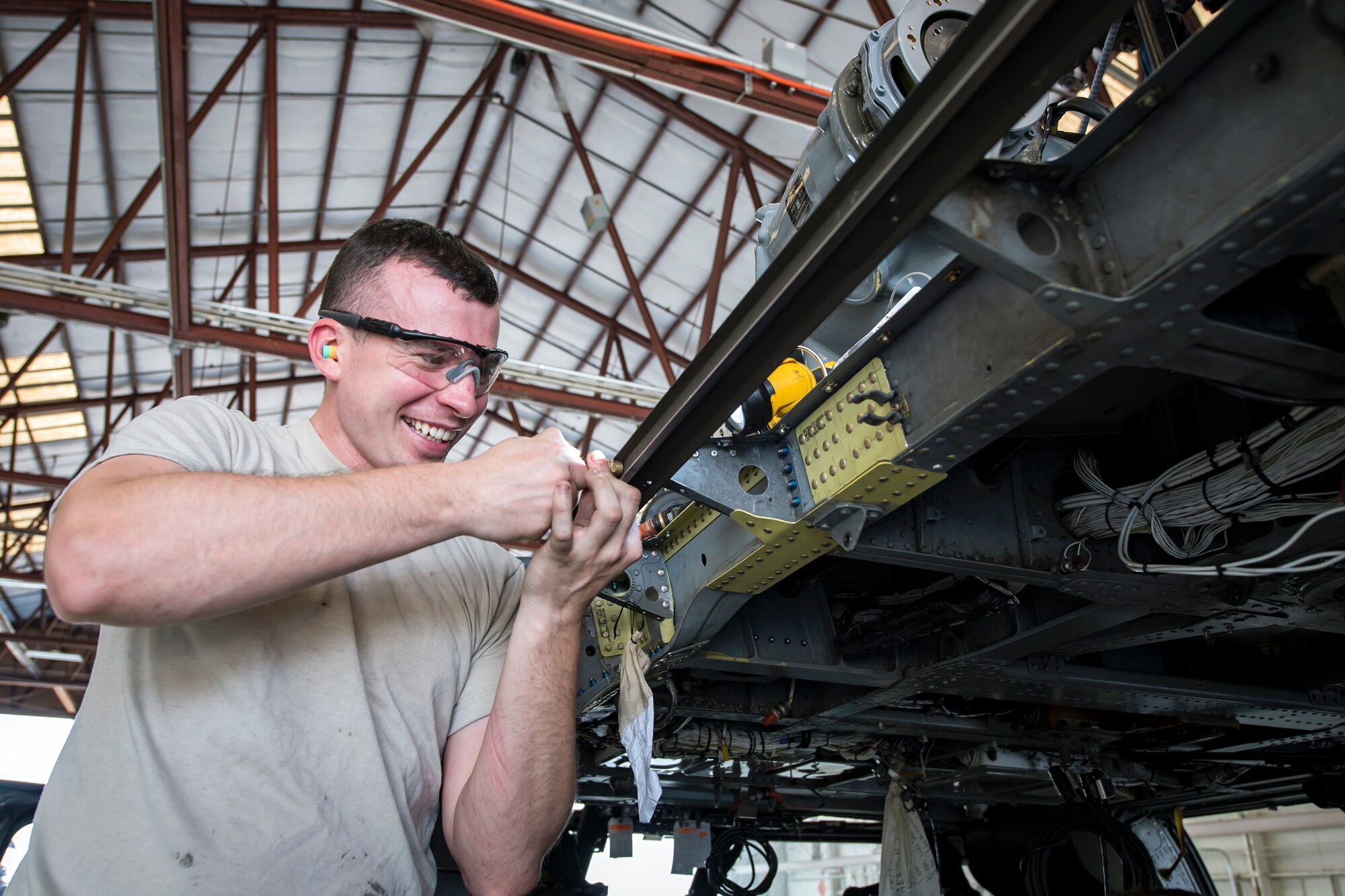 Senior Airman Reed Robitzsch, 723d Aircraft Maintenance (AMXS) Squadron aircraft structural maintenance journeyman, installs the railing on an HH-60G Pave Hawk, May 10, 2018, at Moody Air Force Base, Ga.  Airmen from the 723d AMXS along with machinists from the Corpus Christi Army Depot conducted a full-structural tear down and restoration on an HH-60G Pave Hawk. Once the aircraft was torn down, Airmen and the machinists performed repairs on all of its components prior to resembling it. (U.S. Air Force photo by Airman 1st Class Eugene Oliver)