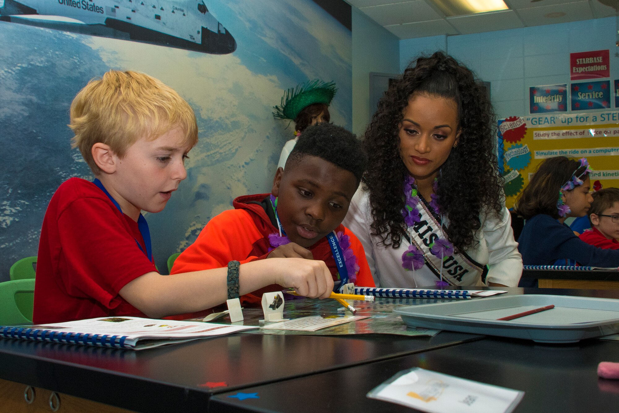 Kara McCullough, Miss USA 2017, helps students with their project during her visit to STARBASE Louisiana on Barksdale Air Force Base, Louisiana, May 15, 2018.