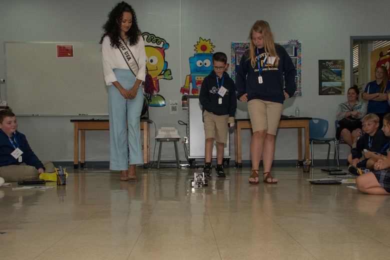 STARBASE Louisiana students demonstrate the robot they programmed as Kara McCullough, Miss USA 2017, looks on during her visit to Barksdale Air Force Base, Louisiana, May 15, 2018.