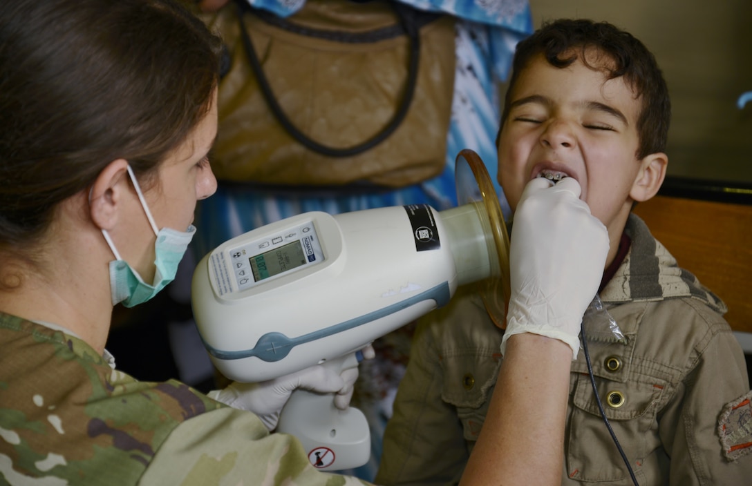 Sgt. Samantha Miller, a dental technician and member of the Utah Army National Guard, takes a dental x-ray on a boy during the Humanitarian Civic Assistance component of Exercise African Lion 2018