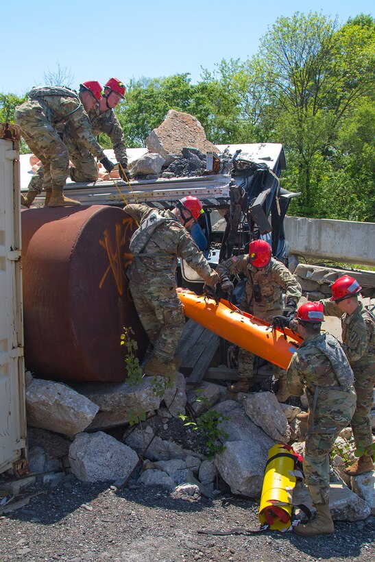 Soldiers move a mock casualty from the debris.