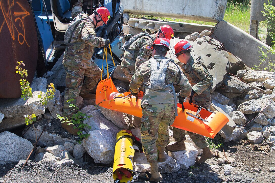 Soldiers move a mock casualty from the debris.