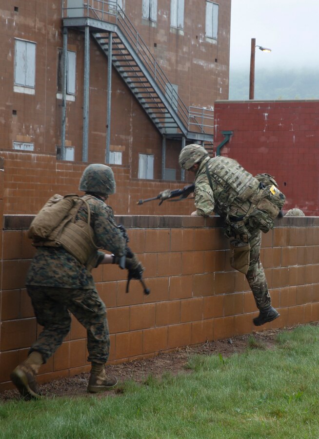 U.S. Marines with 6th Engineer Support Battalion, 4th Marine Logistics Group, and British commando’s with 131 Commando Squadron Royal Engineers, British Army, jump a wall while they practice clearing a village at the military operations on urbanized terrain, or MOUT structure, during exercise Red Dagger at Fort Indiantown Gap, Pa., May 16, 2018. Exercise Red Dagger is a bilateral training exercise that gives Marines an opportunity to exchange tactics, techniques and procedures as well as build working relationships with their British counterparts. (U.S. Marine Corps photo by Sgt. Melanie Wolf/Released)