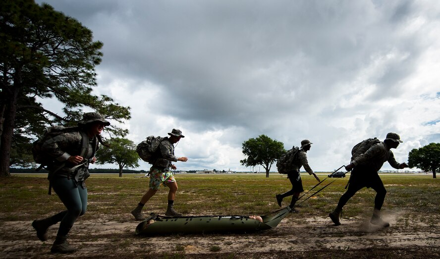 A 96th Security Forces Squadron (SFS) team runs with a simulated victim during the new Warrior Challenge event at Eglin Air Force Base, Fla., May 16, 2018. The Warrior Challenge is a physical activity event created by 96th SFS to highlight security training efforts during Police Week. Teams began a ruck march that led to physical activities like self-aid and buddy care, disassembling and reassembling a weapon and more. (U.S. Air Force photo by Samuel King Jr.)