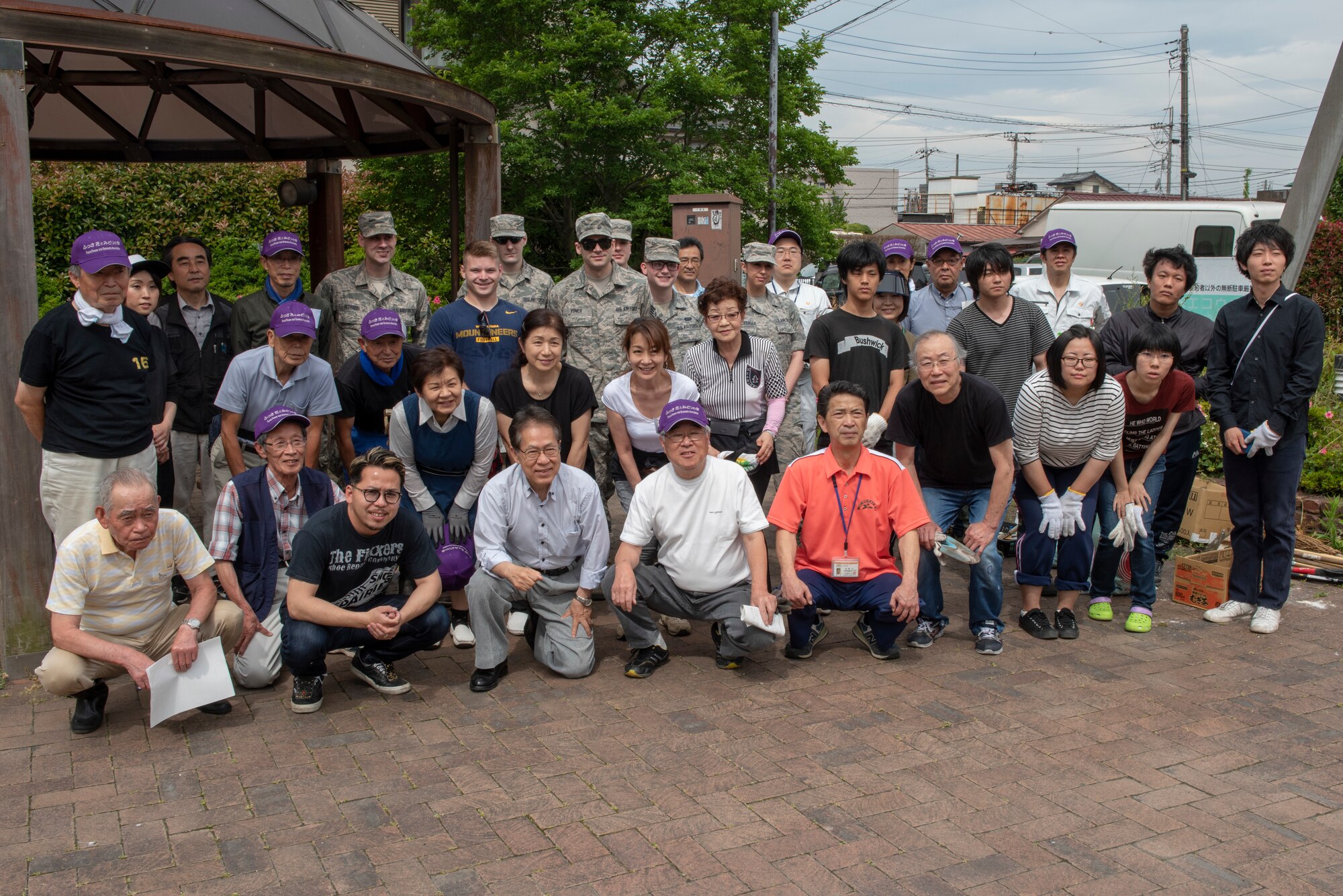 Volunteers from Yokota Air Base, Japan and the city of Fussa, Japan pose for a photo following the closing ceremony on day one of the Fussa Beautification Project in Fussa, May 17, 2018.