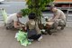 Senior Airman Patrick Heffron, 374th Communications Squadron Operations Flight client systems technician journeyman, left, and Staff Sgt. Matthew Whitton, 374 CS OF client systems technician craftsman, right, team up with a  volunteer from the local community to plant flowers for the Fussa Beautification Project outside of Yokota Air Base, Japan in Fussa May 17, 2018.
