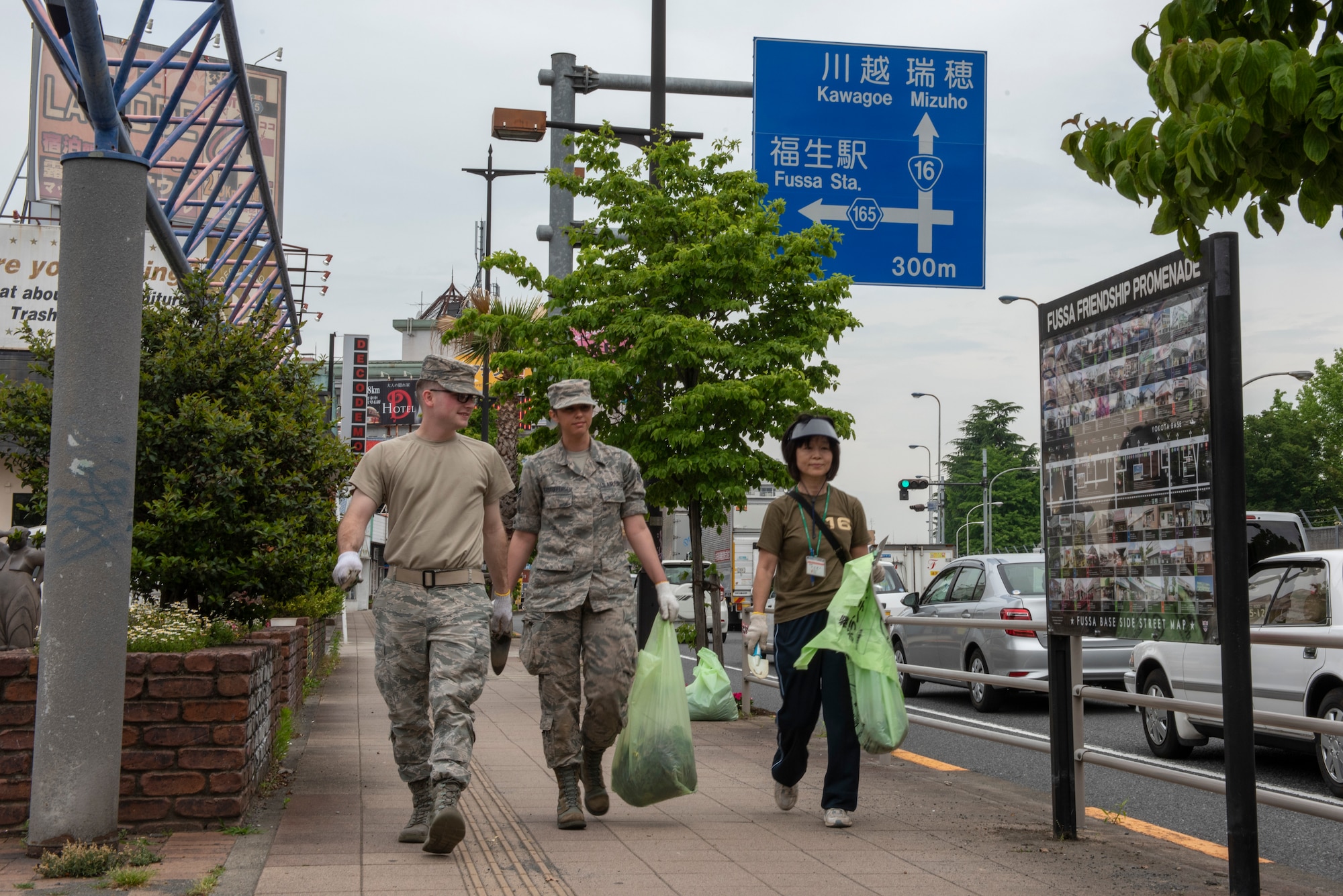 Volunteers from Yokota Air Base, Japan and the city of Fussa carry bags of weeds to be disposed of immediately following the Fussa Beautification Project in Fussa, May 17, 2018.