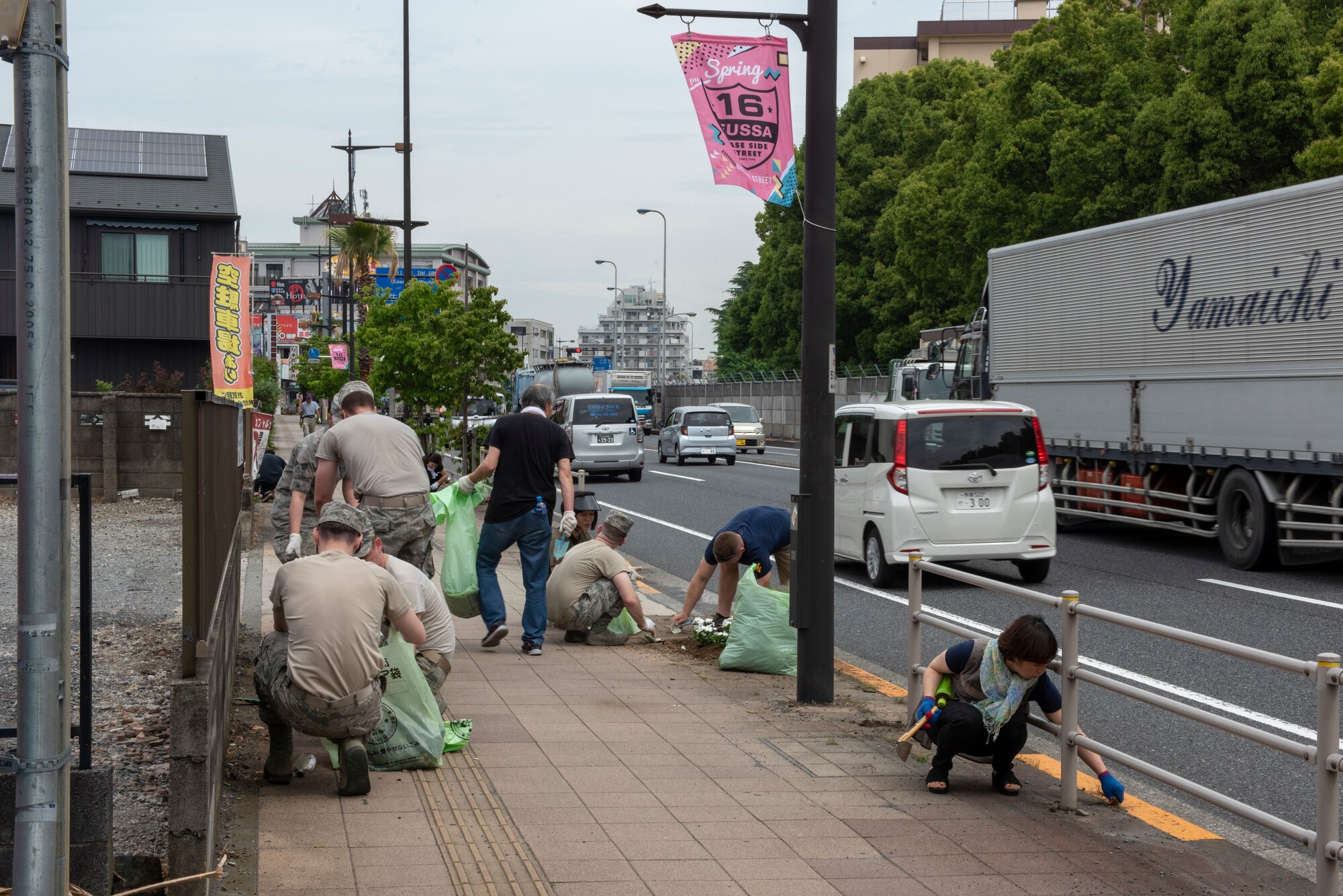 Volunteers from Yokota Air Base, Japan and the city of Fussa complete the finishing touches of cleaning up after the Fussa Beautification Project in Fussa, May 17, 2018.