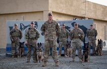 From left to right: U.S. Air Force Military Working Dog Handlers Staff Sgt. Brandon Ouderkirk, Staff Sgt. Carmen Pontello, Staff Sgt. Jeffrie Kennedy, Staff Sgt. Cody Howey, Staff Sgt. Dustin Reed, and Staff Sgt. Patrick Cushing pose for a group photo with their military working dogs, Kon-ga, Max, Eros, Szuli, and Tuko at the 380th Air Expeditionary Squadron K-9 facility, Al Dhafra Air Base, United Arab Emirates, May 15, 2018. (U.S. Air National Guard photo by Tech. Sgt. Nieko Carzis)