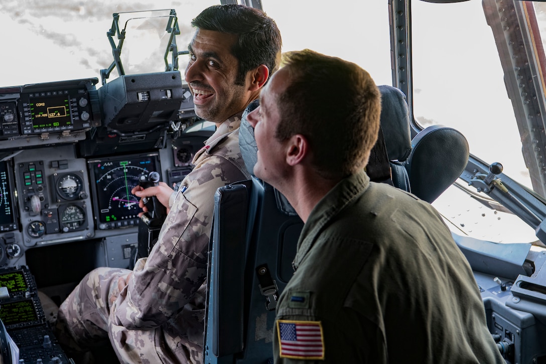 Brig. Gen. Yousef Al Kuwari, the Qatar Defense Attaché, laughs with a pilot from the 167th Airlift Wing as he grabs the controls of a C-17 Globemaster III May 14, 2018 at McLaughlin Air National Guard Base, Charleston, W.Va. Members of the Qatar Defense Attaché Office of the Qatar Embassy in the United States, representing Qatar’s Ministry of Defense, discussed developing further relationships between Qatar and West Virginia during their visit. (U.S. Air National Guard Photo by Airman 1st Class Caleb Vance)