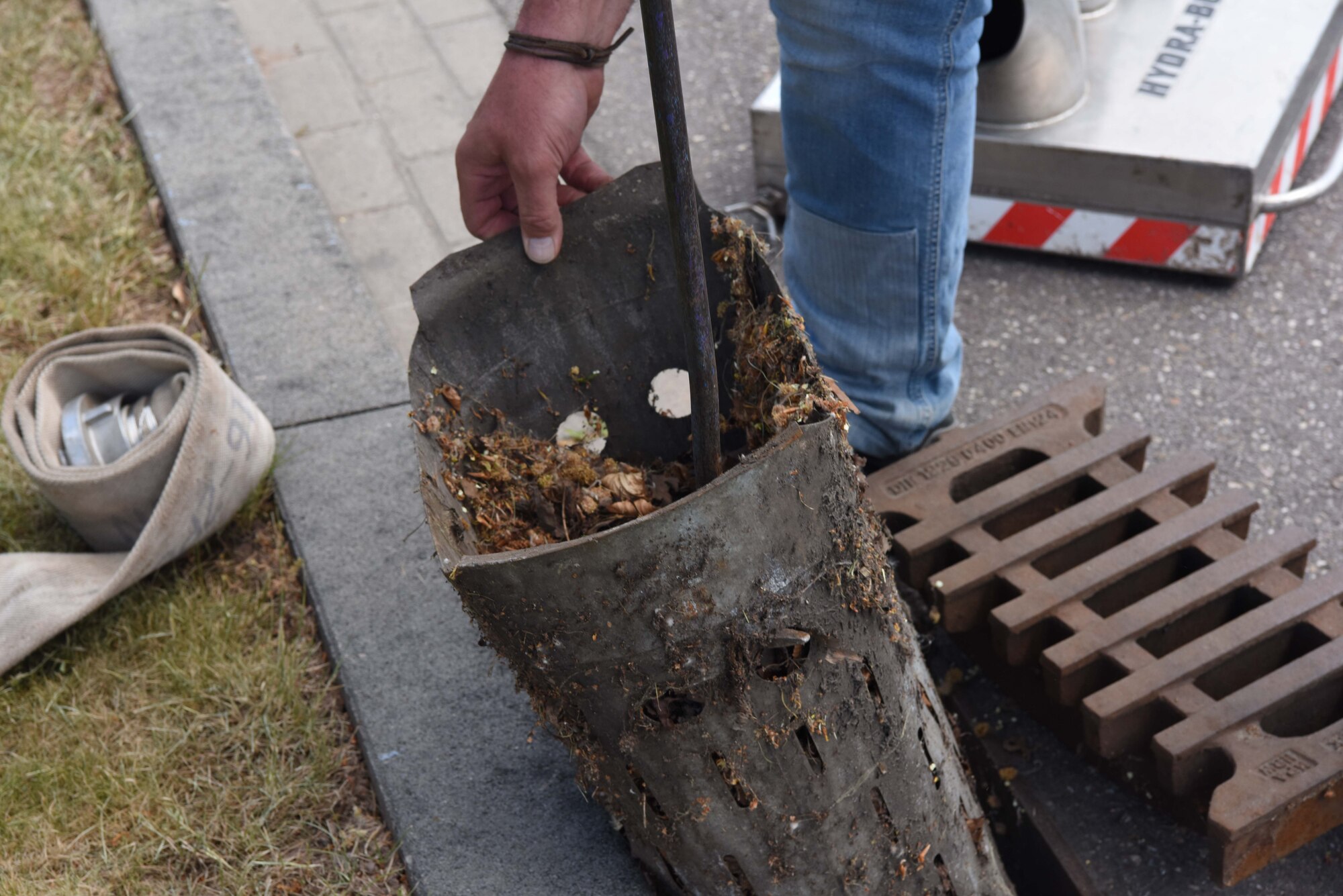 Volker Gehres,water-plant mechanic, 786th Civil Engineer Squadron, cleans out a gutter near a fire hydrant on Ramstein Air Base, Germany, May, 9, 2018. Gehres cleaned the gutter to prepare for the water that will be flushed out during the test.