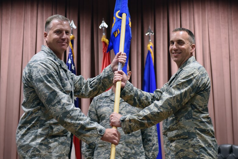 U.S. Air Force Col. David Eaglin, 39th Air Base Wing commander, presents the guidon to Col. Christopher Estridge, 39th Medical Group commander, during a change of command ceremony at Incirlik Air Base, Turkey, May 18, 2018.
