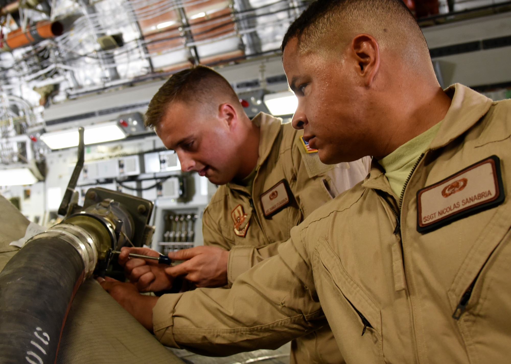 Airman 1st Class Tanner O'Laughlin (left) and Staff Sgt. Nicolas Sanabria (right) secure a fuel hose to a 2,800 gallon fuel bladder at Al Udeid Air Base, Qatar, May 11, 2018. This delivery is the first of its kind in more than a year and a half. (U.S Air Force photo by Staff Sgt. Enjoli Saunders)