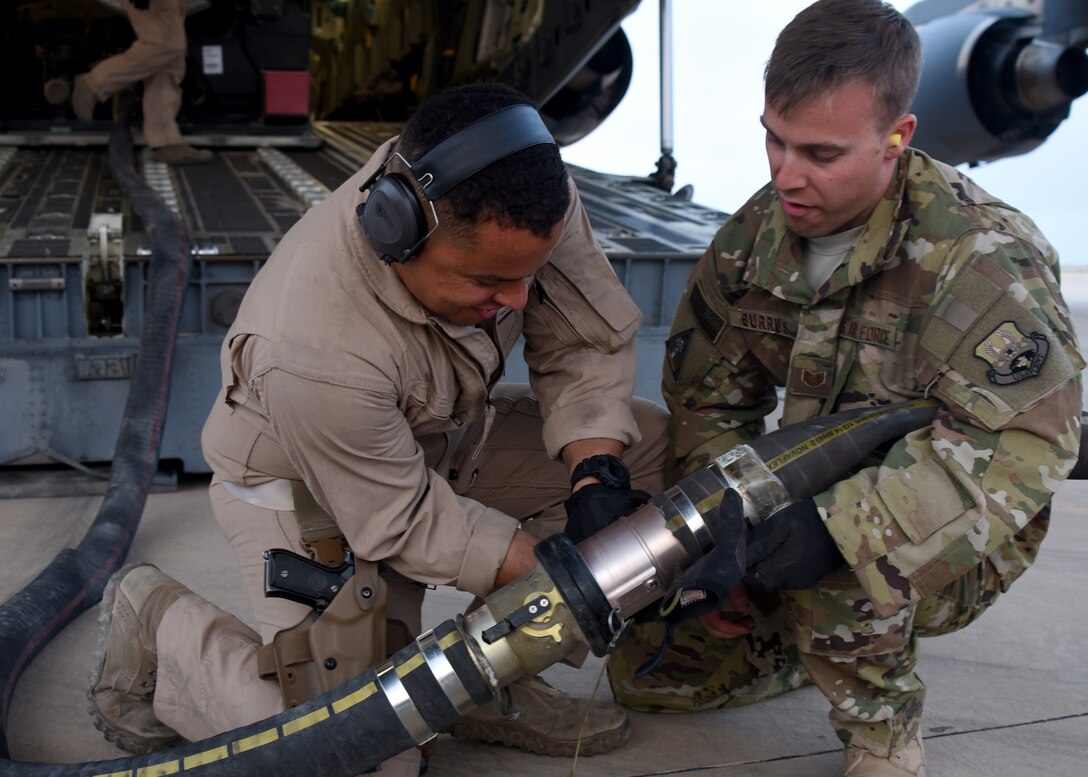 Staff Sgt. Nicolas Sanabria (left) and Tech. Sgt. Stuart Burrus (right) ensure a fuel distribution hose is properly connected in an undisclosed location in Southwest Asia, May 11, 2018. This delivery is the first of its kind in more than a year and a half. (U.S Air Force photo by Staff Sgt. Enjoli Saunders)