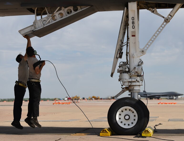 Airman 1st Class Codie Mendoza, left, 9th Aircraft Maintenance Unit load crew member, and Senior Airman Nick Niro, 9th AMU B-1B Lancer assistant dedicated crew chief, assist in closing the crew-entry ladder of a B-1 on the flightline at Dyess Air Force Base, Texas, May 8, 2018. Niro was instructed to close this ladder by the crewmembers in the flight deck of the B-1. (U.S. Air Force photo by Airman River Bruce)
