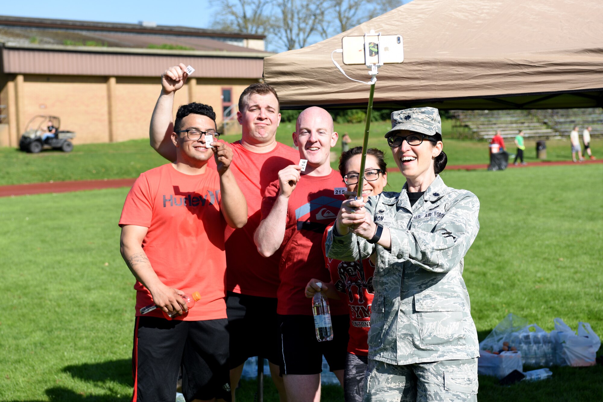 Lt. Col. Kelli R. Moon, commander of the 48th Force Support Squadron, poses for a selfie with Airmen participating in a relay run as part of the 48th Force Support Squadron's "You Got Served" events at Royal Air Force Lakenheath, England, May 4, 2018. During the relay run participating squadrons recieved raffle tickets for cash prizes between $10 and $1,000.