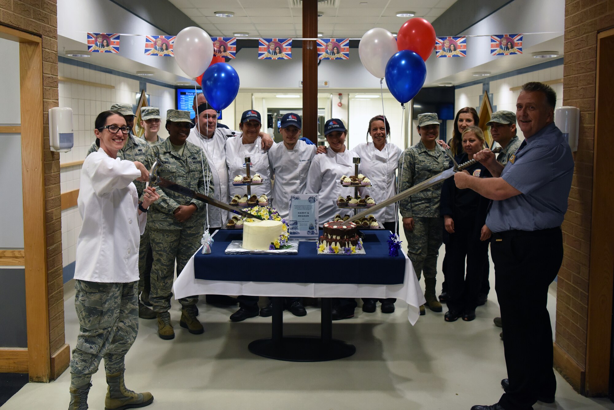 Lt. Col. Kelli R. Moon, commander of the 48th Force Support Squadron, and staff from the Knight's Table Dining Facility pose for a photo as part of the 48th Force Support Squadron's "You Got Served" events at Royal Air Force Lakenheath, England, May 18, 2018. The Knight's Table Dining Facility held a Royal Wedding cake cutting event for dining facility patrons. (U.S. Air Force Photo/ Airman 1st Class John A. Crawford)