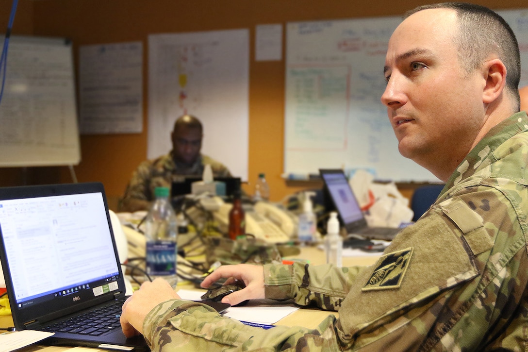Army Capt. Ryan Berg, Task Force Power Restoration Material Manager, converses with teammates on "Bill of Materials" data at the Puerto Rico Electric Power Authority headquarters building, San Juan, Puerto Rico, March 7.