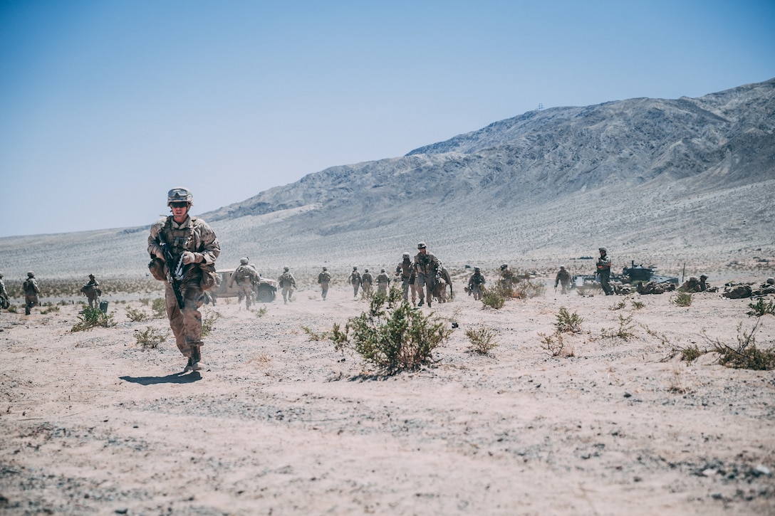 Marines with 3rd Battalion, 2nd Marine Regiment, 2nd Marine Division, run to Amphibious Assault Vehicles to start their counterattack during the Regiment Assault Course at Training Area Quackenbush as a part of Integrated Training Exercise 3-18 aboard the Marine Corps Air Ground Combat Center, Twentynine Palms, Calif., May 15, 2018. The purpose of ITX is to create a challenging, realistic training environment that produces combat-ready forces capable of operating as an integrated Marine Air Ground Task Force. (U.S. Marine Corps photo by Lance Cpl. William Chockey)