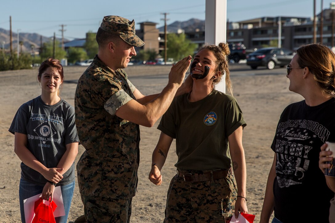 1st. Lt. Curtis Krueger, communications officer, Combat Logistics Battalion 7, demonstrates how to apply camouflage paint on his wife, Ashlie Stapp, during the unit’s Jane Wayne Day aboard the Marine Corps Air Ground Combat Center, Twentynine Palms, Calif., May 10, 2018. Jane Wayne Day gave the spouses a glimpse into the day-to-day lives of their active duty spouses through the combat convoy simulator, a live-fire range and a combat fitness test. (U.S. Marine Corps photo by Lance Cpl. Margaret Gale)