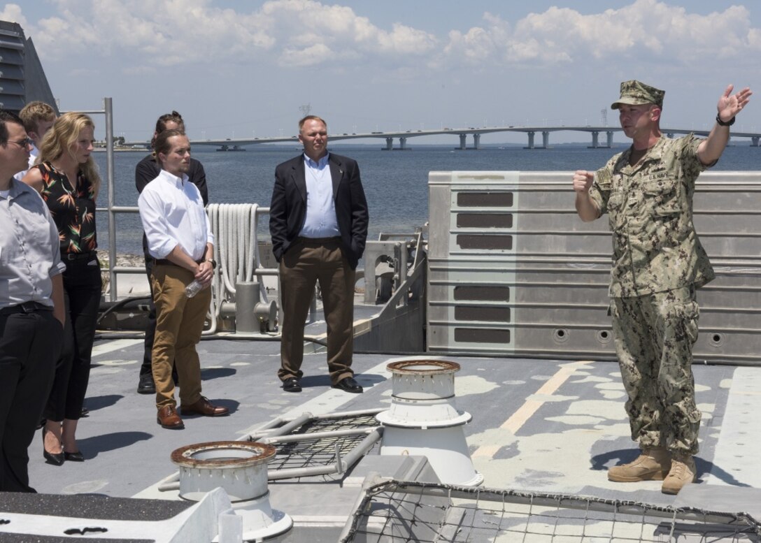 Naval Engineering and Education Consortium college students listen to Senior Chief Petty Officer Josh Pearsall, assigned to Assault Craft Unit FOUR Detachment Panama City, explains the mission and science behind landing craft air cushions during a visit to Naval Surface Warfare Center Panama City Division May 10, 2018. (RELEASED) U.S. Navy photo by Ronnie Newsome, NSWC PCD.