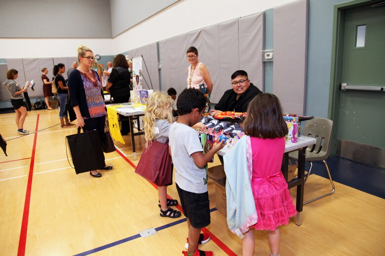 Families crowd around booths during the Combat Center School Liaison Kindergarten Parent Transition Workshop at the MCCS Community Center aboard Marine Corps Air Ground Combat Center, Twentynine Palms, Calif., May 9, 2018. The annual event drew 38 parents and 32 children. (U.S. Marine Corps photo by Kelly O'Sullivan)
