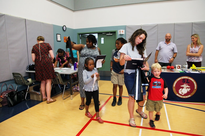 Families enter the MCCS Community Center aboard Marine Corps Air Ground Combat Center, Twentynine Palms, Calif., May 9, 2018, for the annual Combat Center School Liaison Kindergarten Parent Transition Workshop. The event drew 38 parents and 32 children. (U.S. Marine Corps photo by Kelly O'Sullivan)