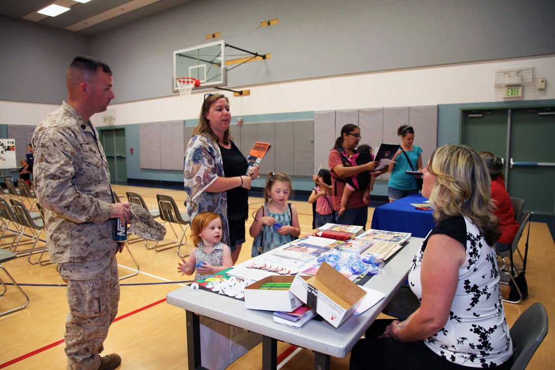 Staff Sgt. Alan Shaw, 3rd Battalion, 11th Marine Regiment, his wife, Kylie, and daughters, Nora, 2, and Ainsley, 4, chat with representatives of Twentynine Palms Head Start during the Combat Center School Liaison's annual Kindergarten Parent Transition Workshop, May 9, 2018. The event at the MCCS Community Center aboard Marine Corps Air Ground Combat Center, Twentynine Palms, Calif., drew 38 parents and 32 children. (U.S. Marine Corps photo by Kelly O'Sullivan)