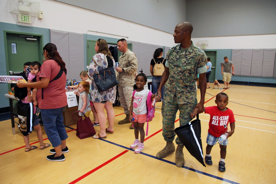 Staff Sgt. Abayomi Adeniyi, instructor, Charlie Company, Marine Corps Communication-Electronics School, walks through the Combat Center School Liaison Kindergarten Parent Transition Workshop with his 4-year-old daughter, Grace, and 2-year-old son, Samuel, May 9, 2018. The event at the MCCS Community Center aboard Marine Corps Air Ground Combat Center, Twentynine Palms, Calif., drew 38 parents and 32 children. (U.S. Marine Corps photo by Kelly O'Sullivan)