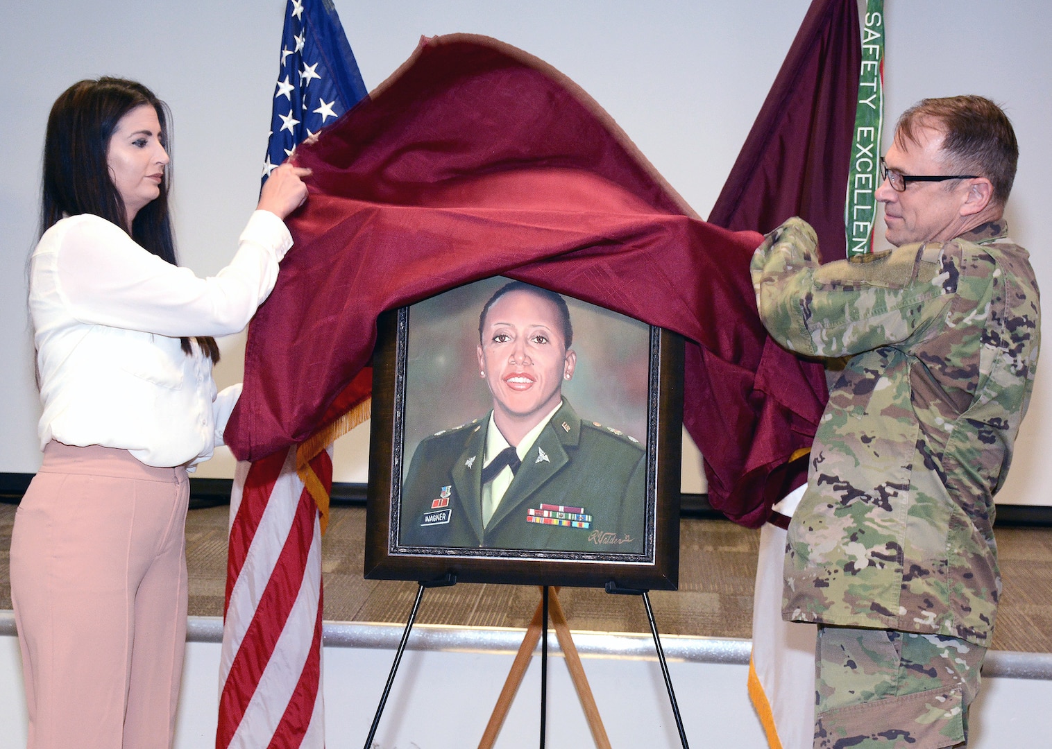 Kourtney Valdez (left), daughter of Richard Valdez, and Maj. Gen. Brian C. Lein, commanding general, U.S. Army Medical Department Center & School, unveil the painting of Lt. Col. Karen Wagner.