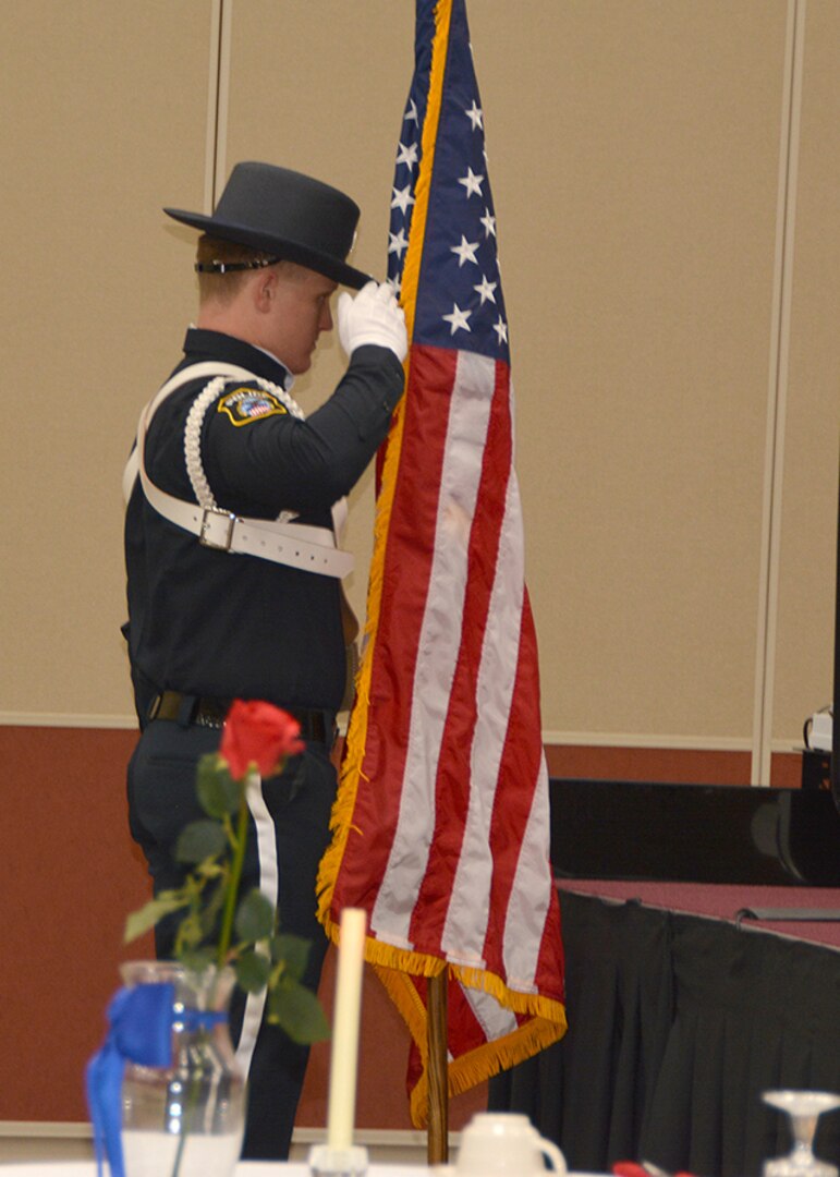 Officer salutes flag during ceremony