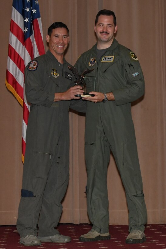 Lt. Col. Christopher Chandler, the 93rd Bomb Squadron director of operations, presents the Lindell Mabus Leadership Award to Capt. Jacob Stawski during a graduation ceremony on Barksdale Air Force Base, La. May 18, 2018.