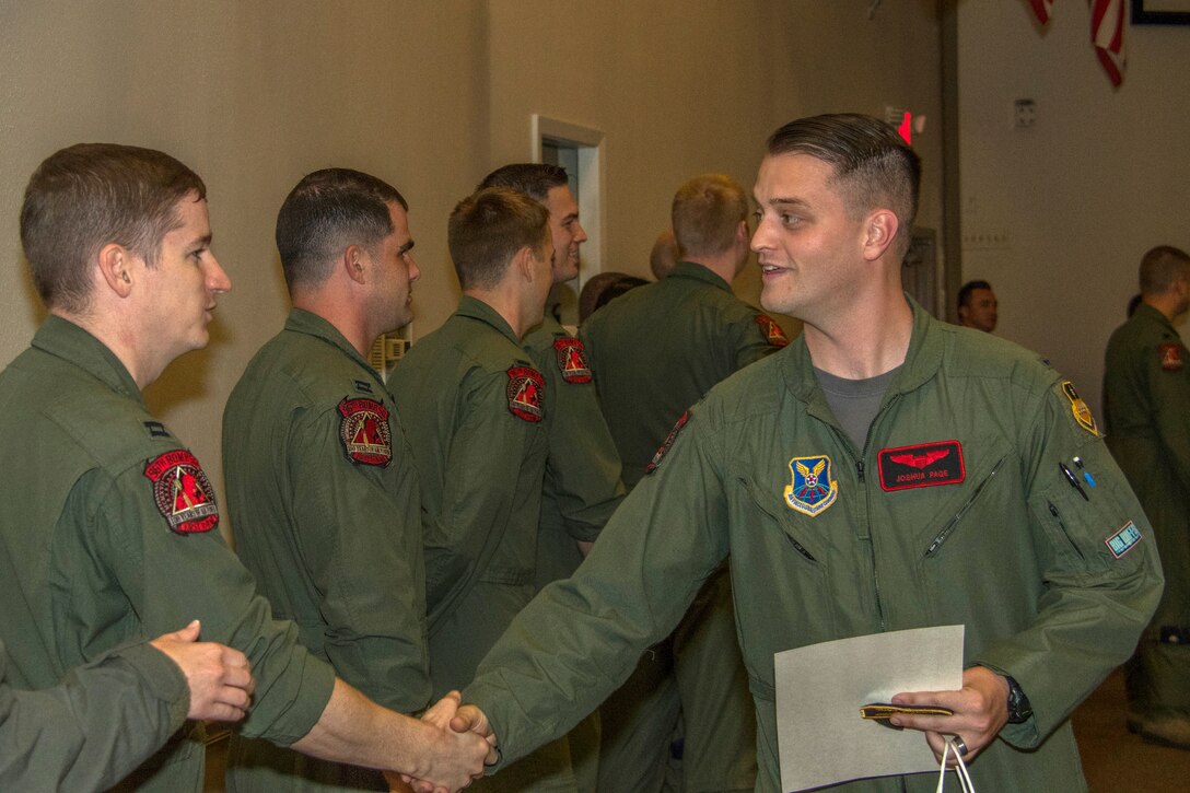 U.S. Air Force 1st Lt. Joshua Page, a student in the B-52 Stratofortress Formal Training Unit Class 17-03, shakes hands with his new fellow aircrew from the 96th Bomb Squadron during his graduation from on Barksdale Air Force Base, Louisiana, May 18, 2018.