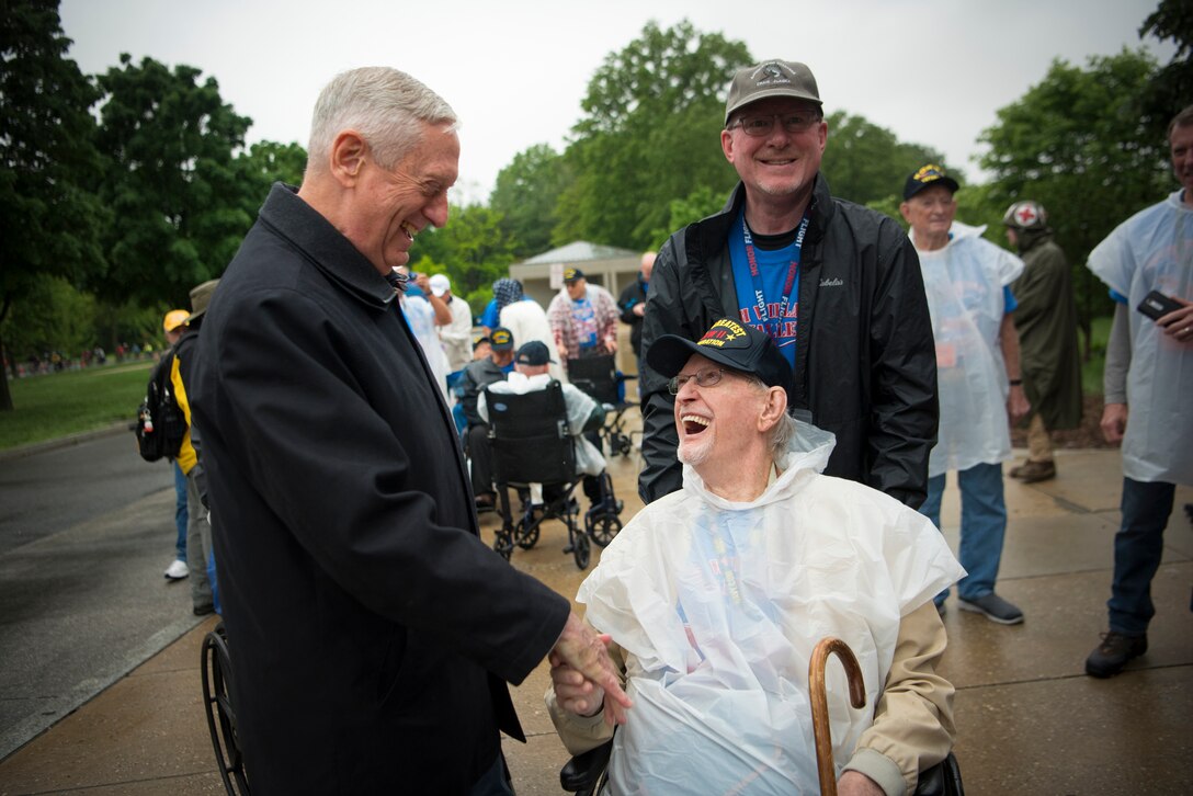 Defense Secretary James N. Mattis shakes hands with a veteran sitting in a wheelchair.