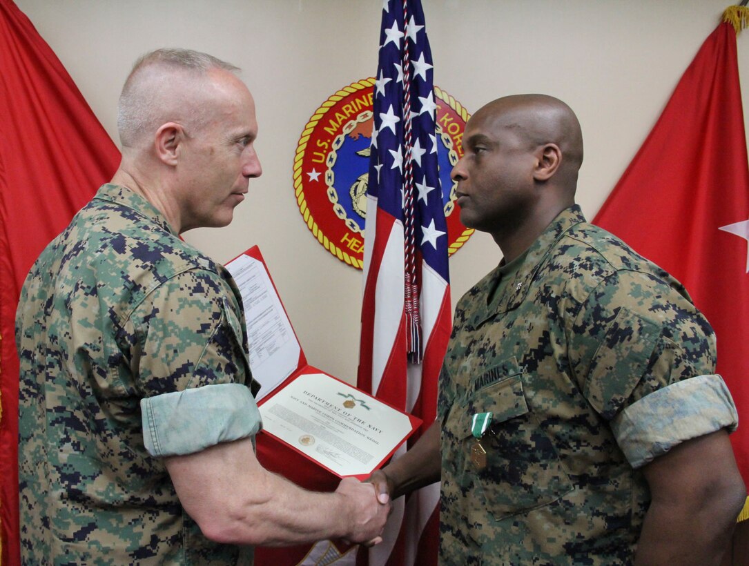 U.S. ARMY GARRISON, YONGSAN – Lt. Col. Daniel J. Thomas (right), U.S. Marine Corps Forces Korea G3 future operations officer, is awarded the Navy and Marine Corps Commendation Medal by Maj. Gen. Patrick J. Hermesmann, MARFORK commander, here, May 11. Thomas, who will report to 4th Marines, was awarded for his outstanding contribution to the command in leading both future operations development and the setup of MARFORK’s future move to Camp Humphreys. (Official U.S. Marine Corps Photo by Sgt. Nathaniel Hanscom/Released)