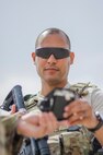 Senior Airman Alexander Hunter, 380th Security Forces, verifies identification at a gate at Al Dhafra Air Base, United Arab Emirates, May 17, 2018. Air Force security forces members are trained in law enforcement and combat arms to protect and serve their fellow Airmen. (U.S. Air National Guard photo illustration by Staff Sgt. Ross Alexander Whitley)