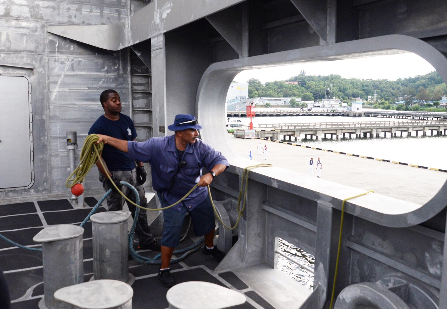 Ronald Stokes, left, assigned to USNS Millinocket (T-EPF 3) observes as Sam Gonzalez heaves the line to Royal Malaysian Navy sailors as the ship pulls into Seppangar Naval Base as part of a U.S. 7th Fleet theater security cooperation patrol. Millinocket will visit several countries in the Indo-Pacific in the coming weeks.