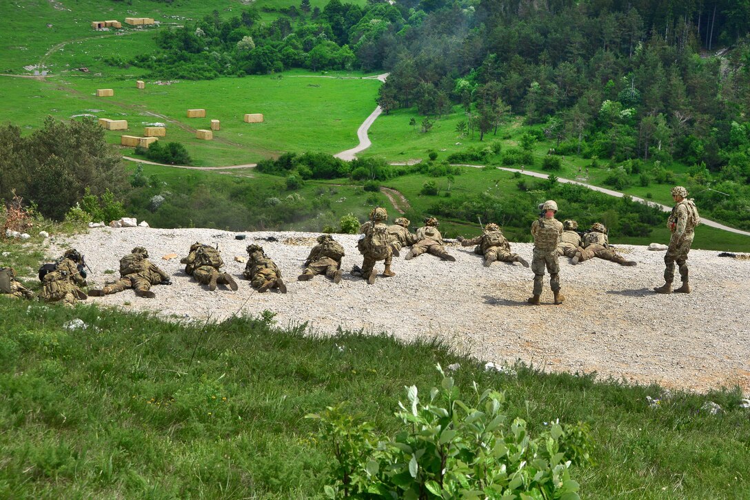 Soldiers engage targets from an elevated firing position during a live-fire exercise.