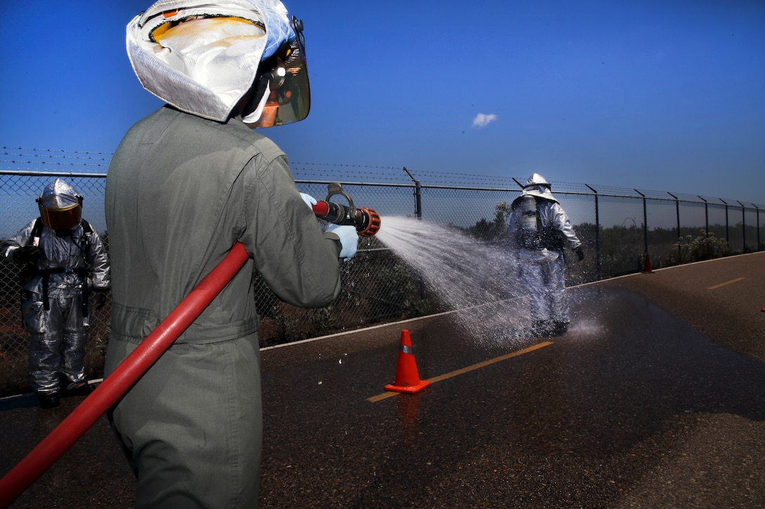 Pfc. Connor Mize, a hazardous material entry team technician with Aircraft Rescue and Fire Fighting, douses Lance Cpl. Luis Da Luz, a HAZMAT entry team technician with ARFF, with a fire hose during the decontamination process of a chemical, biological, radiological, nuclear and high-yield explosive exercise conducted at Marine Corps Air Station Miramar, California, May 17, 2018. The exercise simulated a bioterrorism attack and required several MCAS Miramar units to coordinate an effective response.