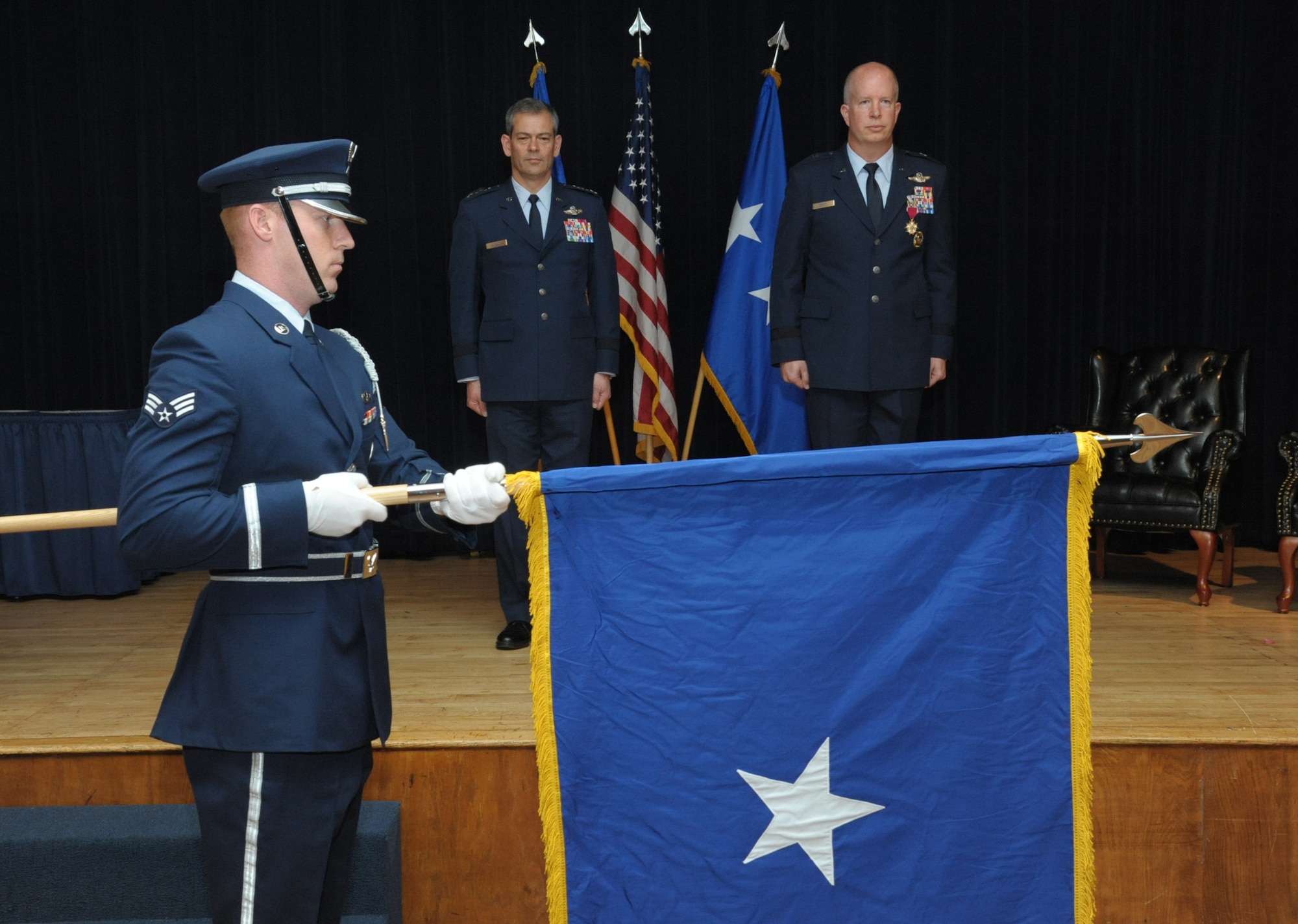 Lt. Gen. Kenneth Wilsbach, commander of Alaskan North American Aerospace Defense Command Region, Alaskan Command, U.S. Northern Command, and Eleventh Air Force, and Col. Joel Carey stand at attention during the personal colors unfurling during Carey’s promotion to brigadier general, May 18, 2018, Joint Base San Antonio-Randolph, Texas. The 12FTW is responsible for four single-source aviation pipelines – Pilot Instructor Training, Combat Systems Officer Training, Remotely Piloted Aircraft Pilot Indoctrination, and Basic Sensor Operator Qualification. (U.S. Air Force by Joel Martinez)