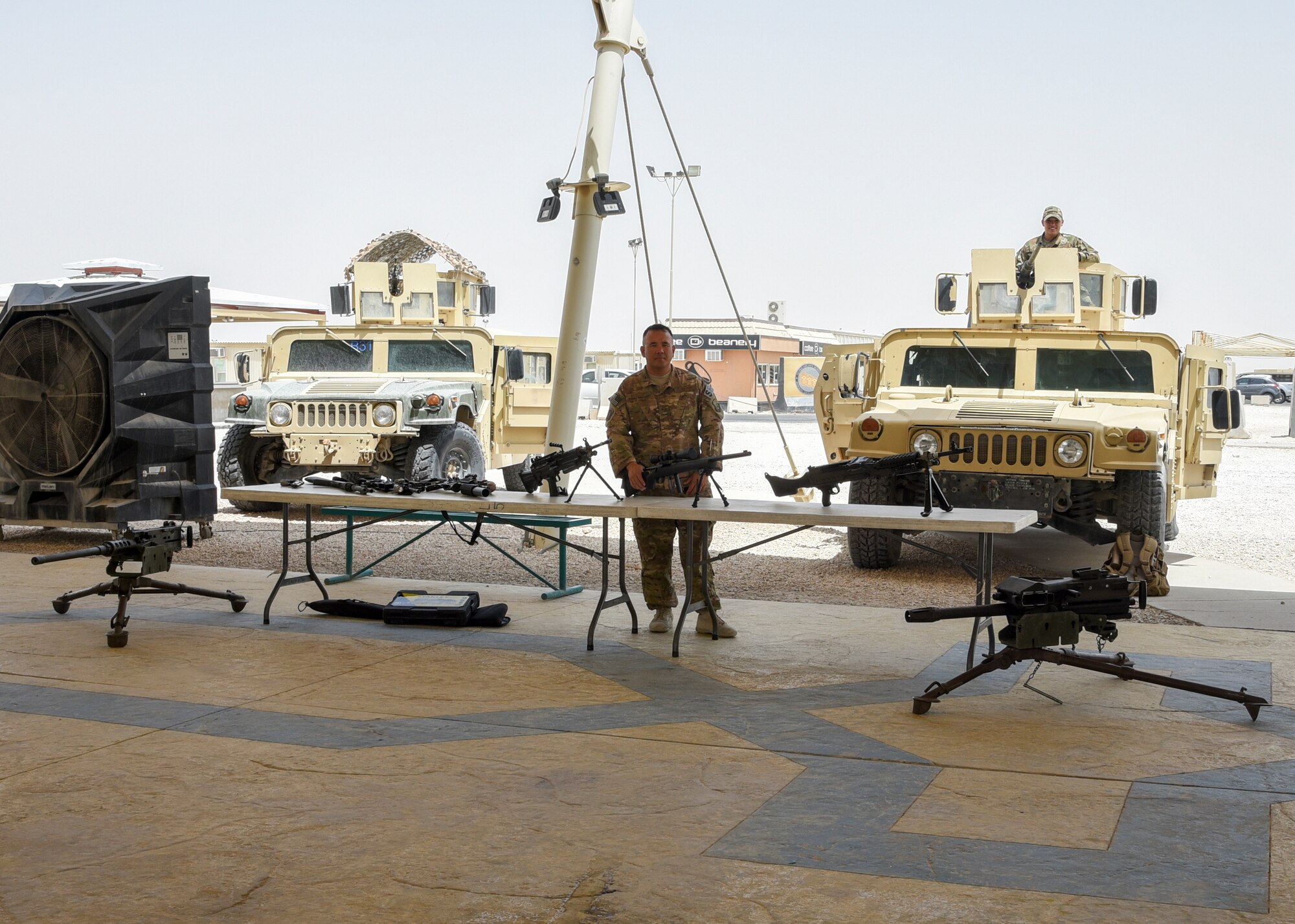 Tech. Sgt. Markus Mindoro, 379th Expeditionary Security Forces Squadron Armory noncommissioned officer in charge, stands behind a static weapons display during National Police Week at Al Udeid Air Base, Qatar, May 16, 2018. Throughout the week, security forces members held numerous events to highlight capabilities and competencies of the squadron. (U.S. Air Force photo by Staff Sgt. Enjoli Saunders)