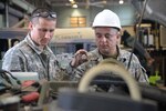 Warrant Officer Ghenadie Varzari and SGT Andrei Dogari, Mechanics with the Moldovan Defense Forces, work together to troubleshoot the issue in a Humvee engine at the North Carolina National Guard Combine Support Maintenance Shop in Raleigh, North Carolina, May 17, 2018. The North Carolina National Guard and the Moldovan Defense Forces have been hosting bi-lateral engagements through the State Partnership Program that has allowed Soldier growth and development for both countries.