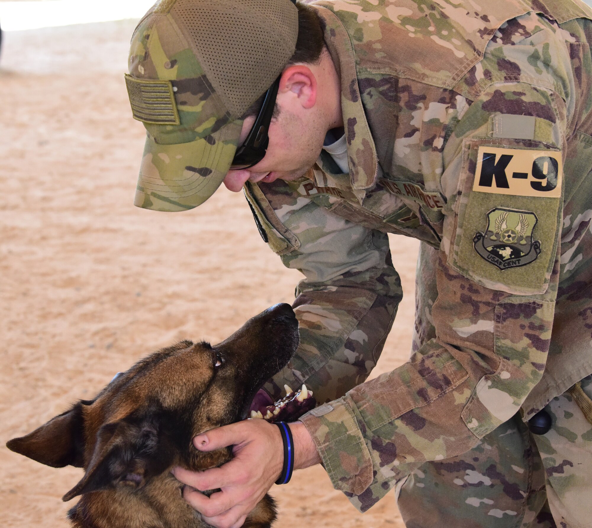 Senior Airman Zakary Phare, 386th Expeditionary Security Forces Squadron military working dog handler, congratulates his K-9 partner, Herceg, on a job well done during a MWD demonstration at an undisclosed location in Southwest Asia, May 18, 2018. Phare and Herceg train daily to ensure readiness for missions supporting Operation Inherent Resolve. (U.S. Air Force photo by Senior Airman Michala Weller)